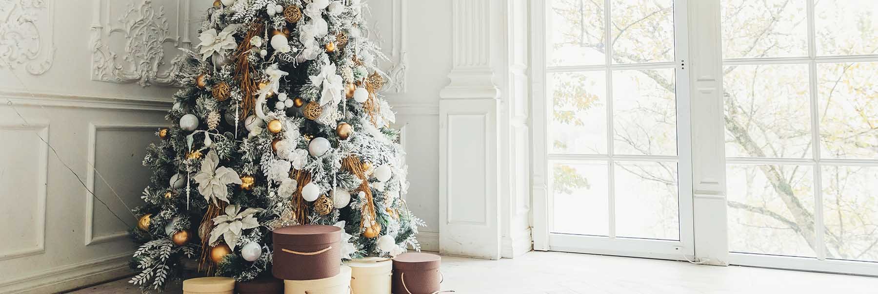 Beautifully decorated Christmas tree in front of a traditional glass door in a luxe bright wood panelled living room