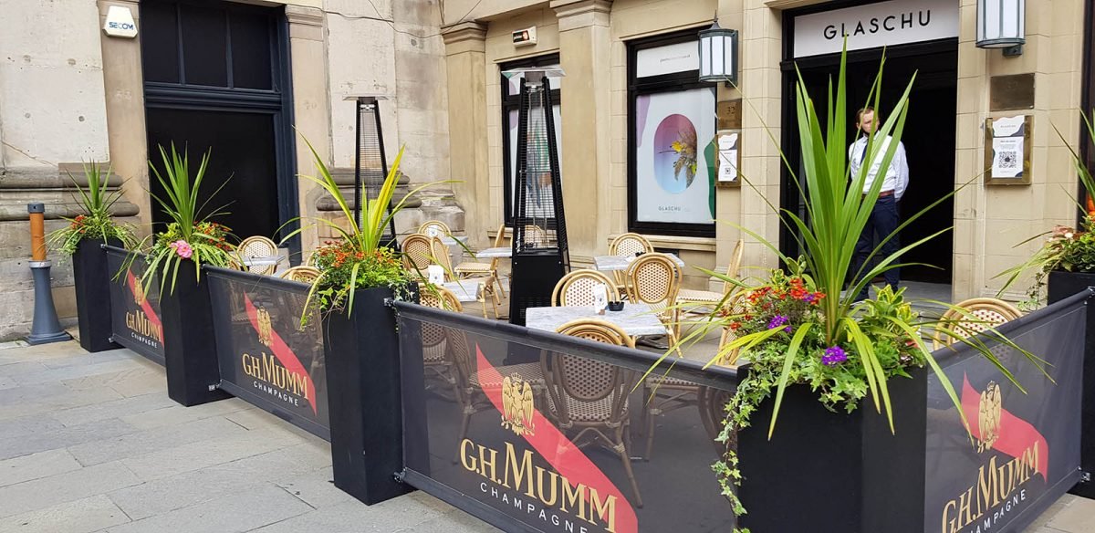 French style bistro pavement café outdoor dining at Glaschu in Glasgow with lush planters and bespoke branded banners
