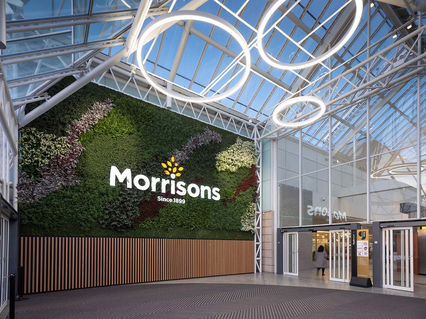 Huge green wall with Morrisons branding at Gyle Shopping Centre Edinburgh planted with artificial plants and Nordik Moss