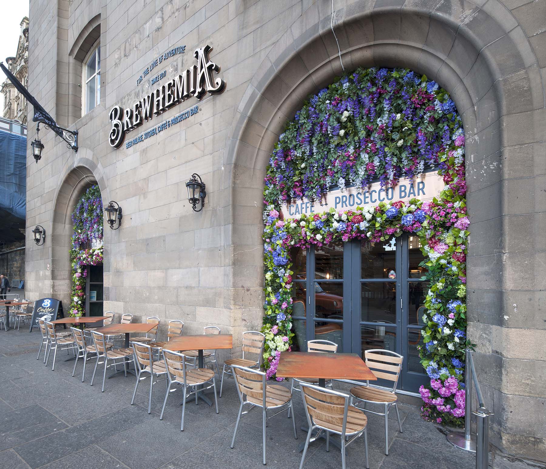 Huge floral frontage feature at Brewhemia Edinburgh with bright colourful artificial flowers for eye-catching entrance