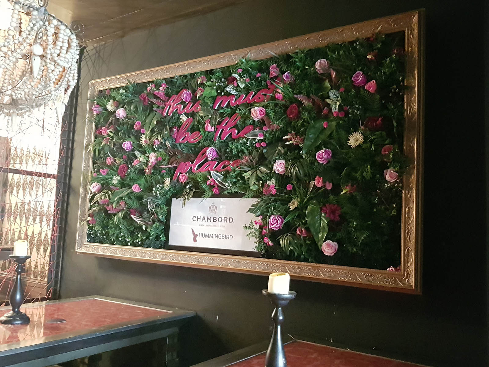 Chambord branded bespoke artificial foliage wall with pink flowers, neon signage and gold frame in Glasgow cocktail bar