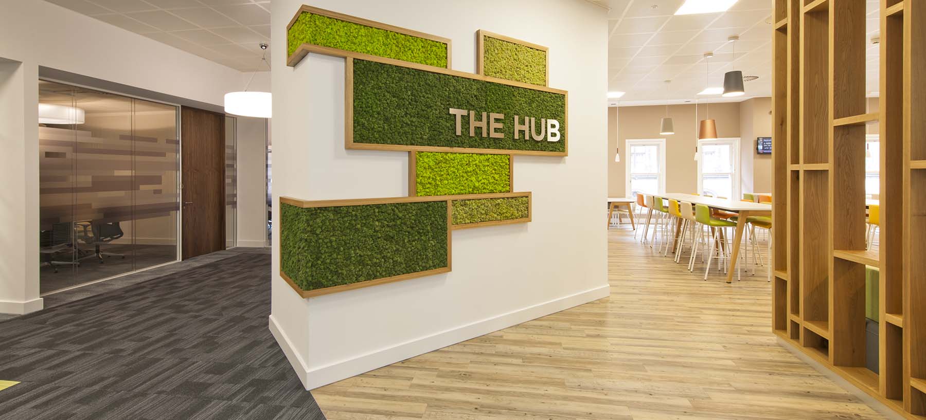 Wraparound Nordik Moss wall feature in bespoke oak frame with stainless steel signage for Glasgow office breakout area