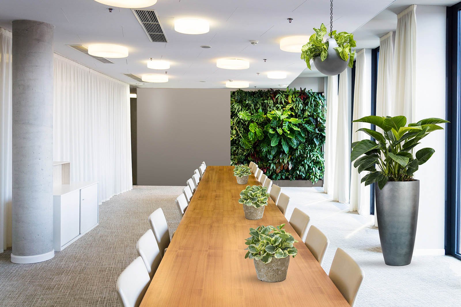 Mock-up of an office space with one half filled with a green wall, lush plants and hanging greenery, the other half bare