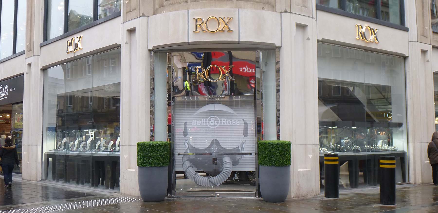 Rox Jewellery High Street retail store with perfectly manicured topiary in tall grey planters flanking the entrance