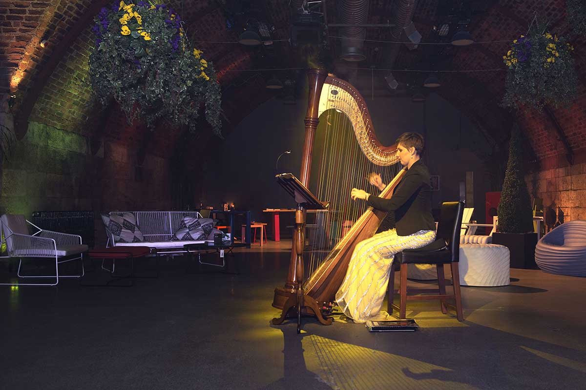 A Harpist plays at Bureau Night Garden event in Glasgow’s Arches. Venue dressed with exterior planters and hanging foliage