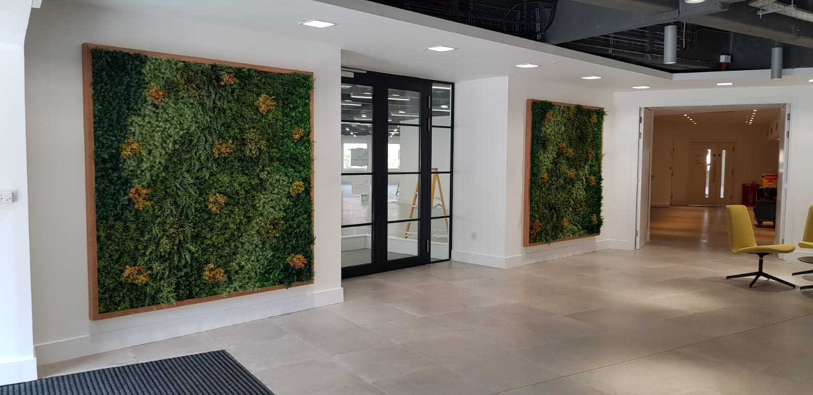 Bespoke artificial green wall foliage panels full of tones and texture in wooden frames hung in office entrance area