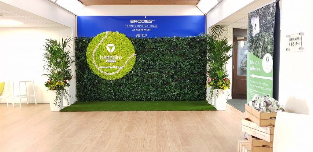 Bespoke selfie wall for Brodies’ event at Gleneagles Hotel with green wall, Nordik Moss tennis ball and live Kentia palms
