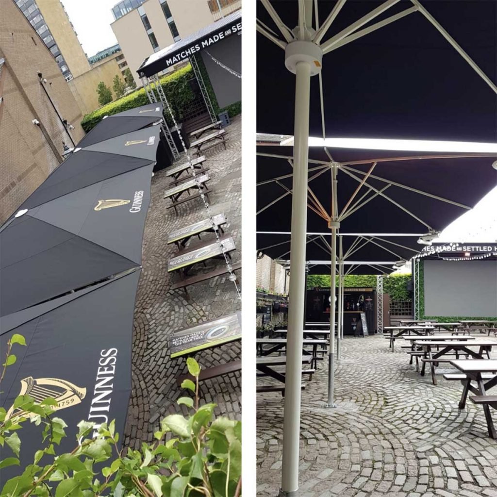 Pear Tree Edinburgh’s outdoor sports terrace with Guinness branded parasols and benches for seating around a big screen