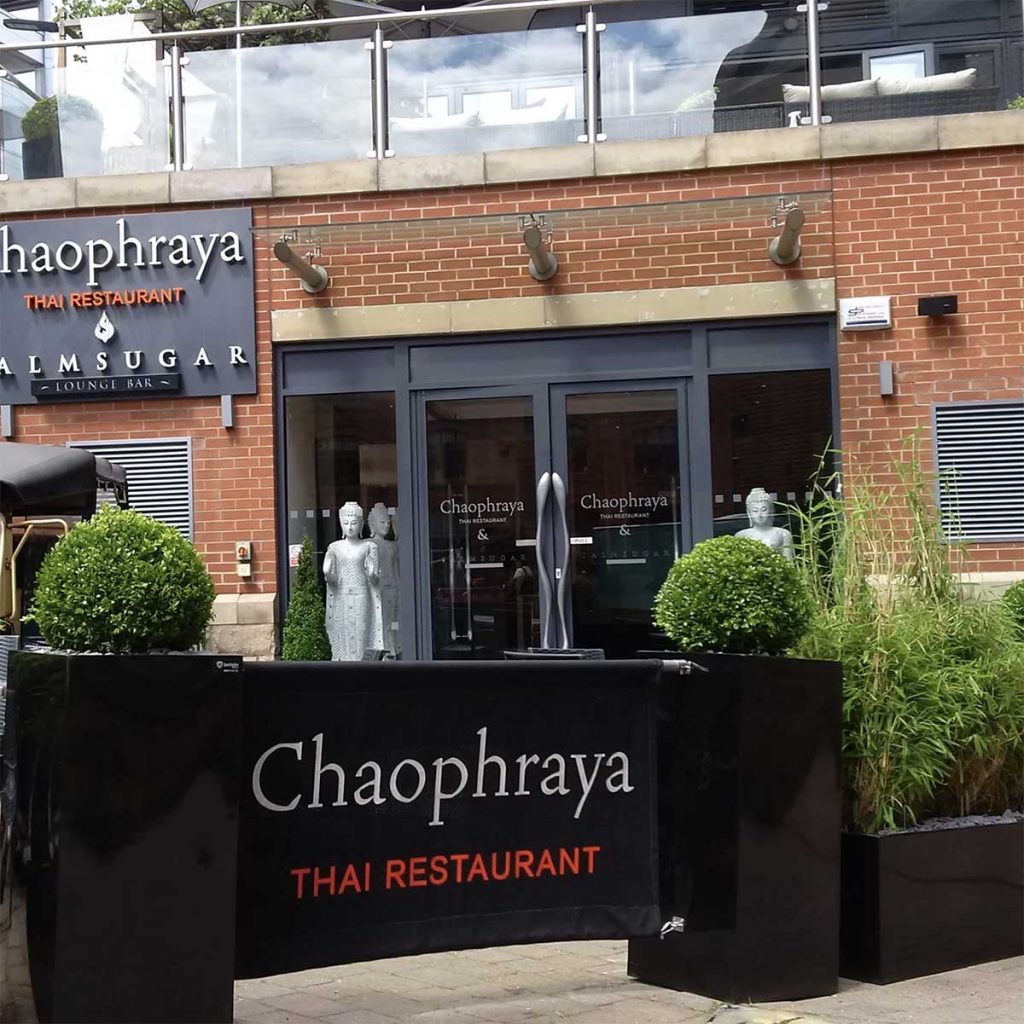 Chaophraya Leeds’ exterior gloss black cube planters with buxus and assorted greenery with black branded banners