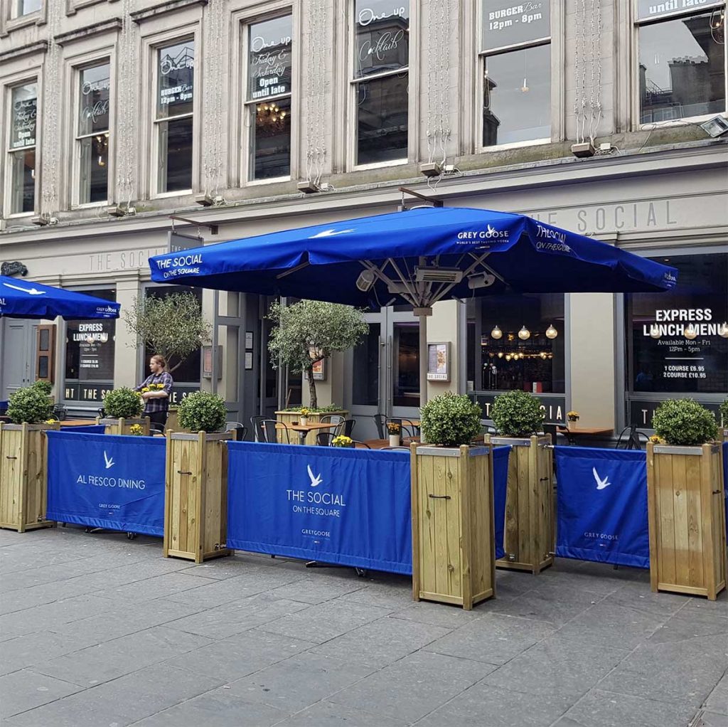 The Social Glasgow’s outdoor dining area with branded, sponsored blue parasols and buxus filled planters