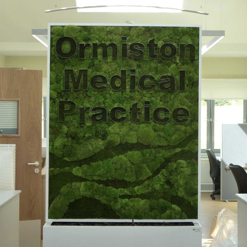 Free standing bespoke patterned Nordik Moss panel for a medical practice with stainless steel edged lettering
