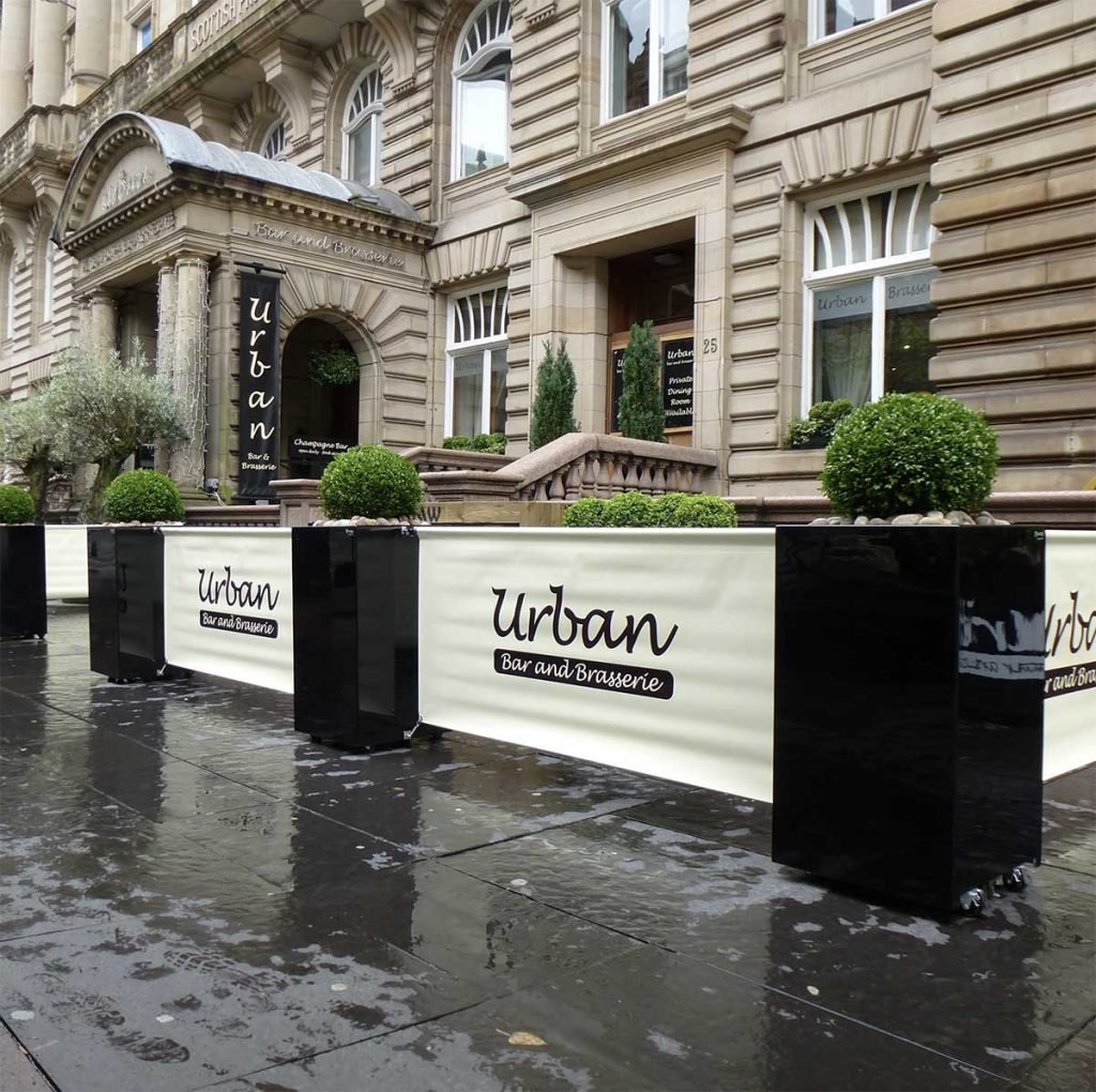 Urban Glasgow’s branded banners and sleek black planters with buxus balls to separate dining pavement dining