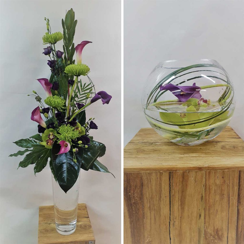 Two Orchid floral arrangements. One with cala lilies in a tall vase, the other with greenery wrapped inside a vase