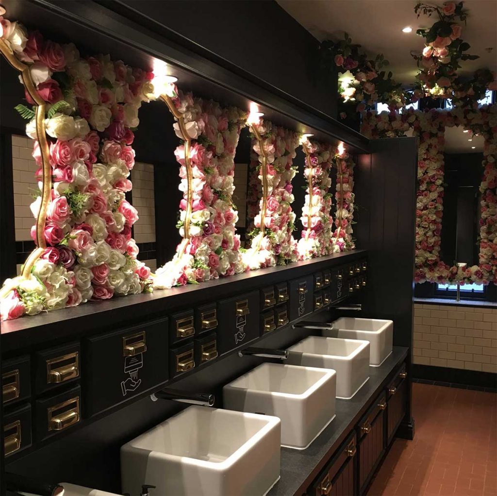 Bathroom mirrors in the Esselmont, Aberdeen with surrounding custom panels of artificial pink and white roses with greenery.