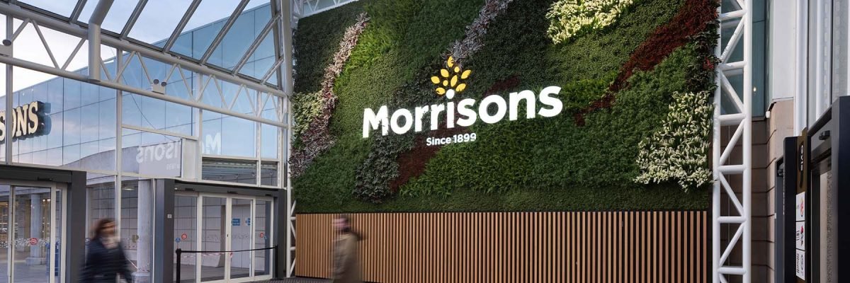 Huge 50 sq m green wall of artificial plants, Nordik Moss and Morrisons supermarket branding welcomes visitors at Gyle Shopping Centre Edinburgh