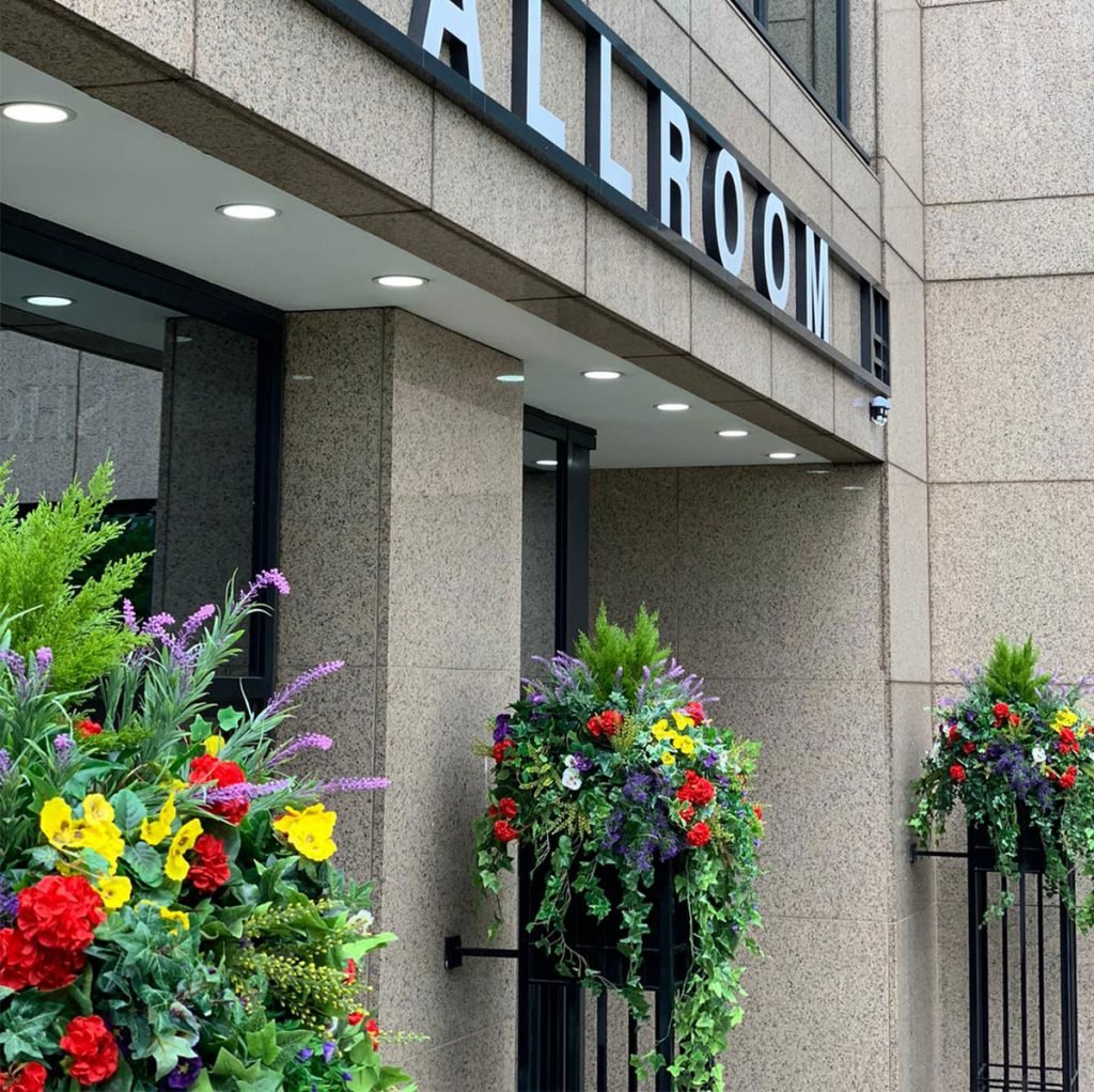 baskets filled with artificial trailing plants, trees and flowers to cheer up this exterior entrance - a beautiful take on the original hanging basket.