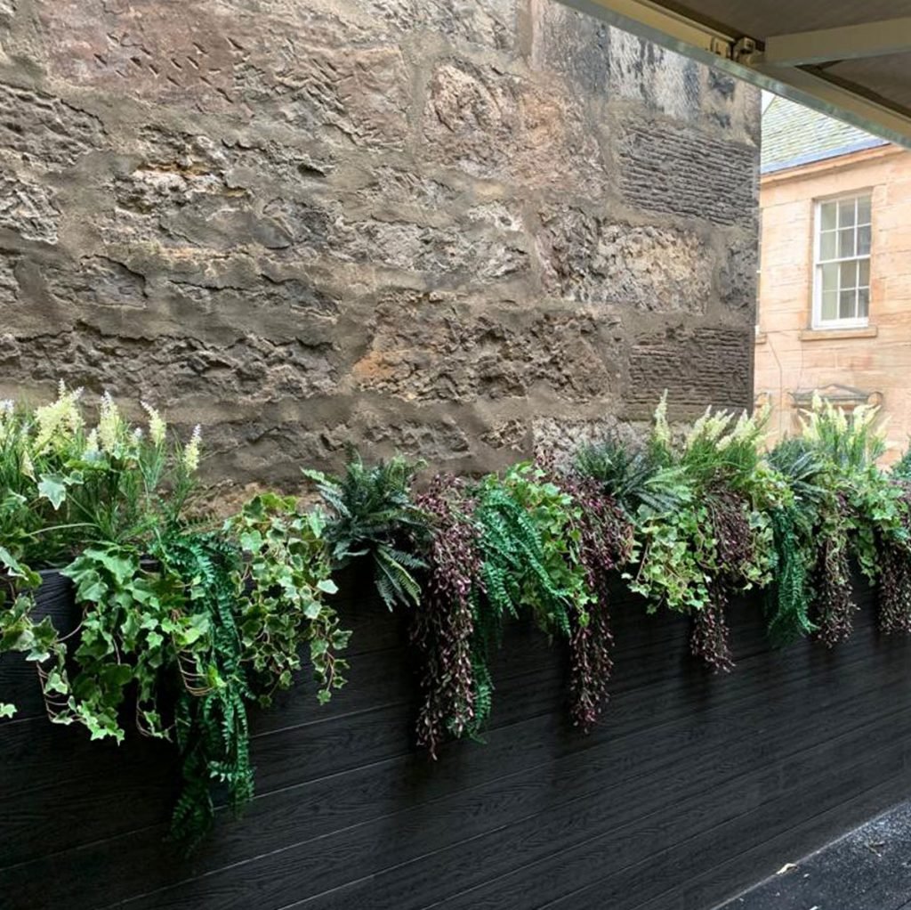 Exterior matt black planters filled with mixed artificial foliage trails