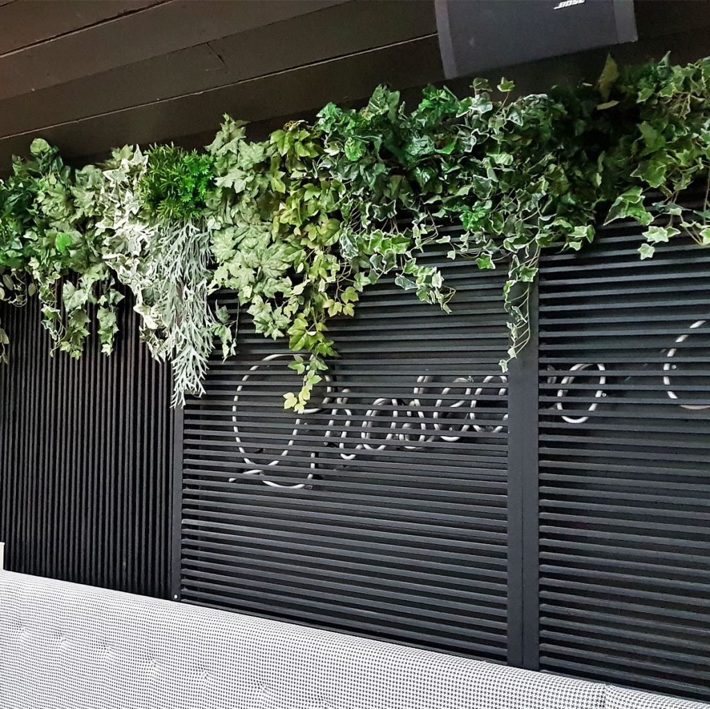Green plants in dark backgrounds look striking and instantly brighten up the space - artificial strip planting is a great way to do this as it required no natural light.
