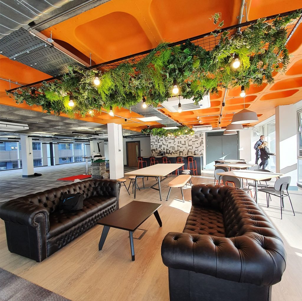 hanging ceiling raft is beautifully decorated with artificial green plants trailing and intertwining through the bars.