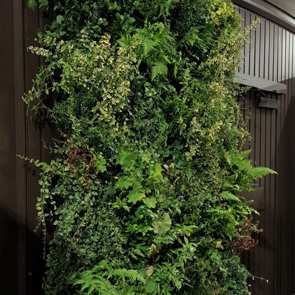 this wild living foliage wall panel looks beautiful against the dark wood at the Glasgow Central Station
