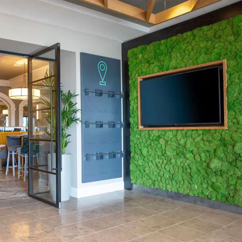 this nordik moss wall makes an instant statement in the reception area at The Ro Hotel, Windermere - featuring Nordik bun moss, this wall was carefully built by hand to make a stunning backdrop for the TV screen.
