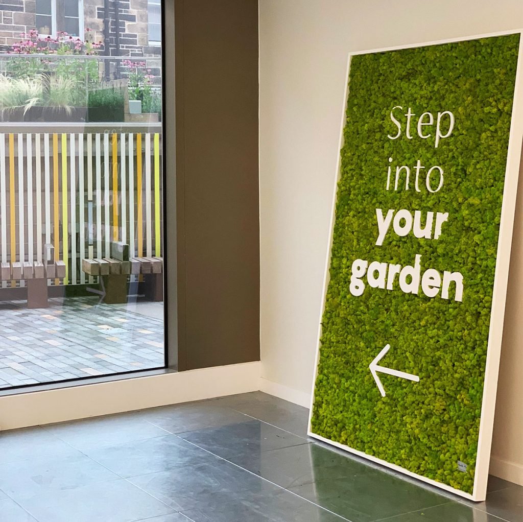 This simple Nordik reindeer moss panel instantly brightens up the plain white wall and is a great alternative to plain signage.