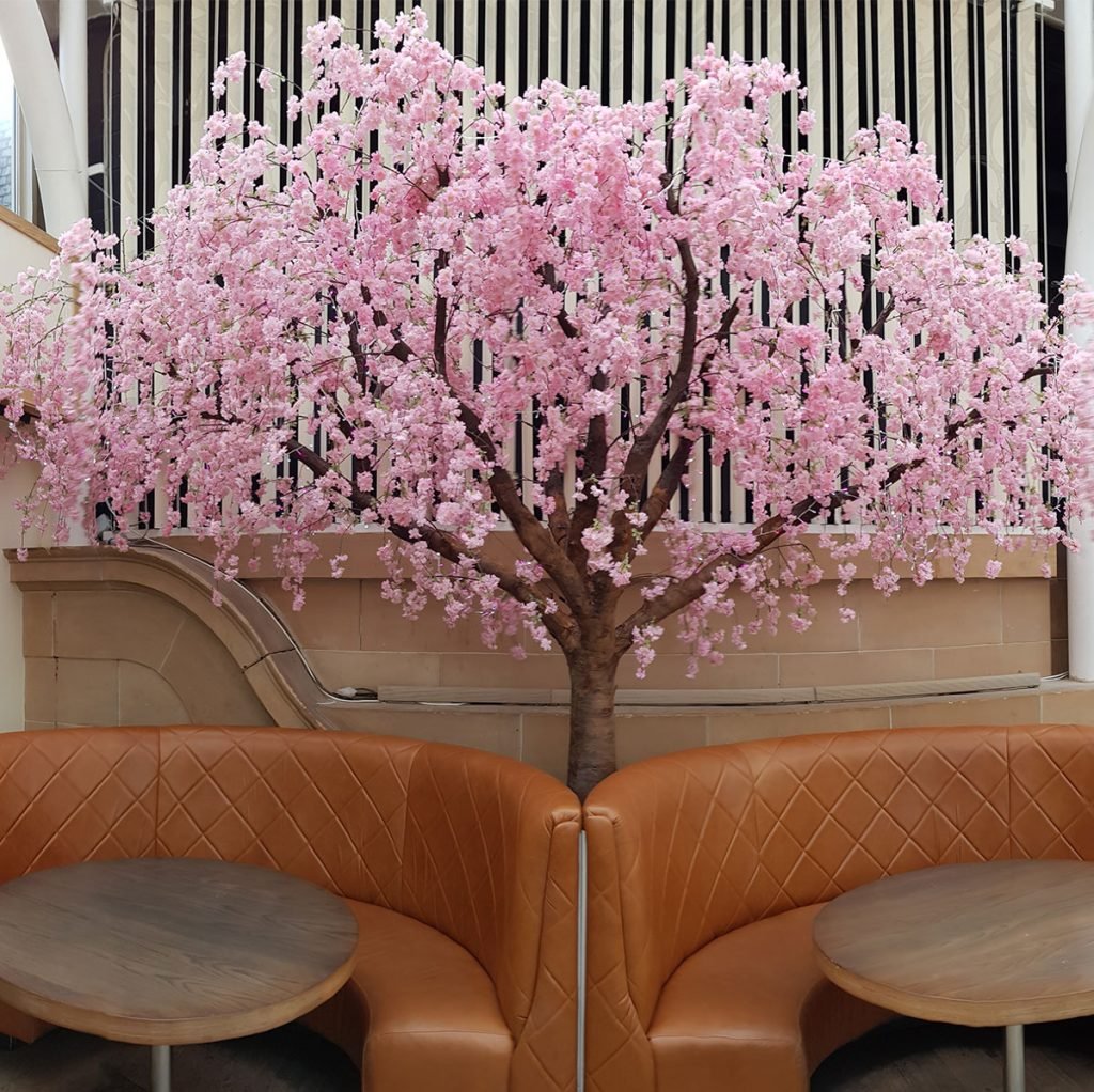 bespoke pink cherry blossom tree hangs over the seating booths at the october restaurant in glasgow, creating a stunning feature