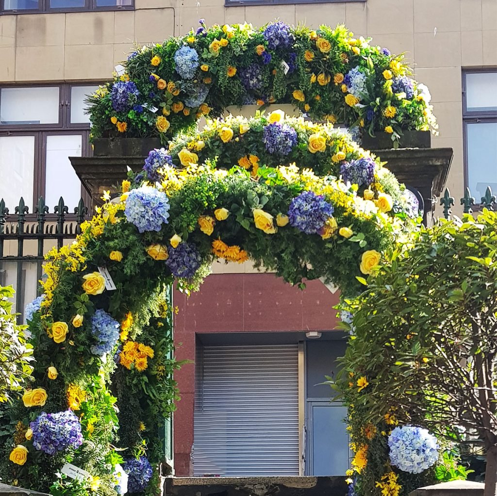 gorgeous bespoke built green archways with blue and yellow floral accents to showcase the bombay sapphire brand at the rose street gardens in edinburgh