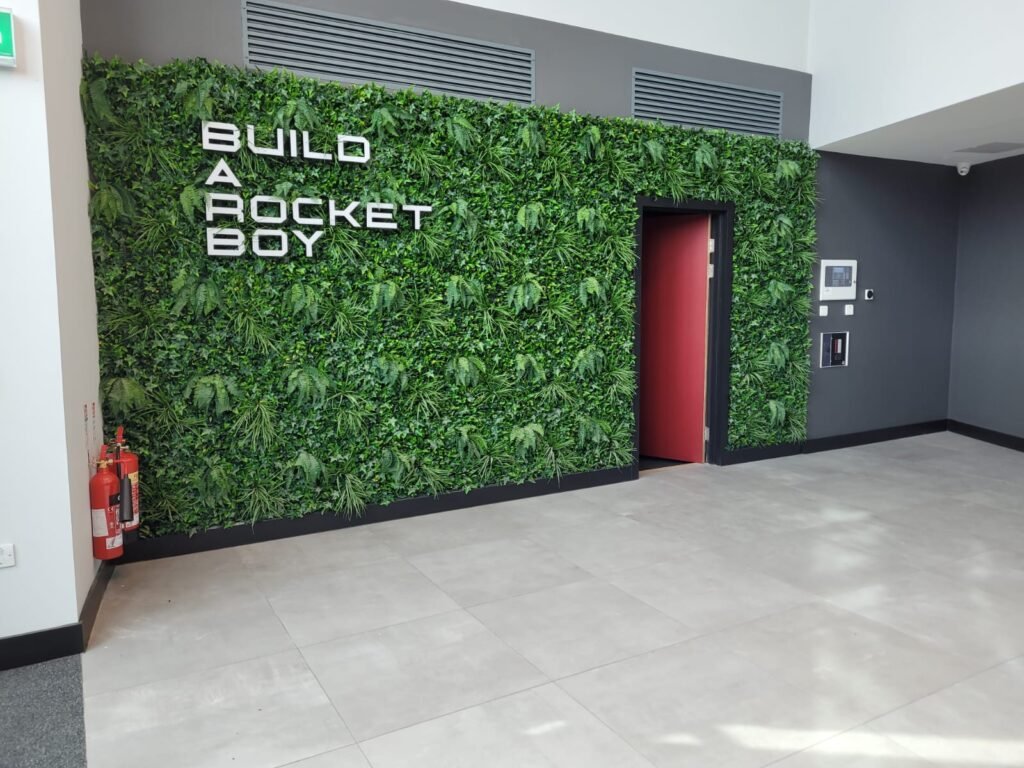 Vibrant bespoke artificial green wall with signage