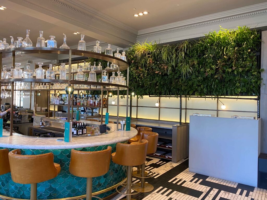 Large high-level green wall in this bar creates a warm, natural atmosphere