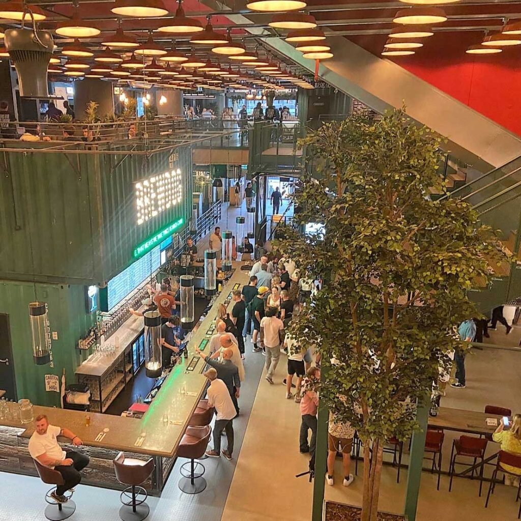 The interior of Brewdog Waterloo is decorated with a tall artificial ficus tree