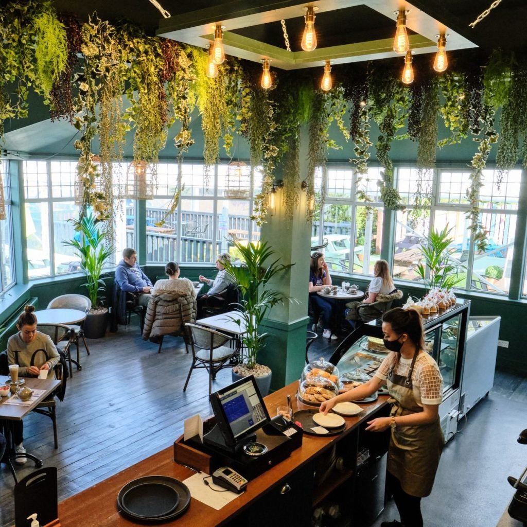 Artificial trailing strip planting lines the ceiling of the fowrie gardens cafe whilst live kentia palms decorate the space
