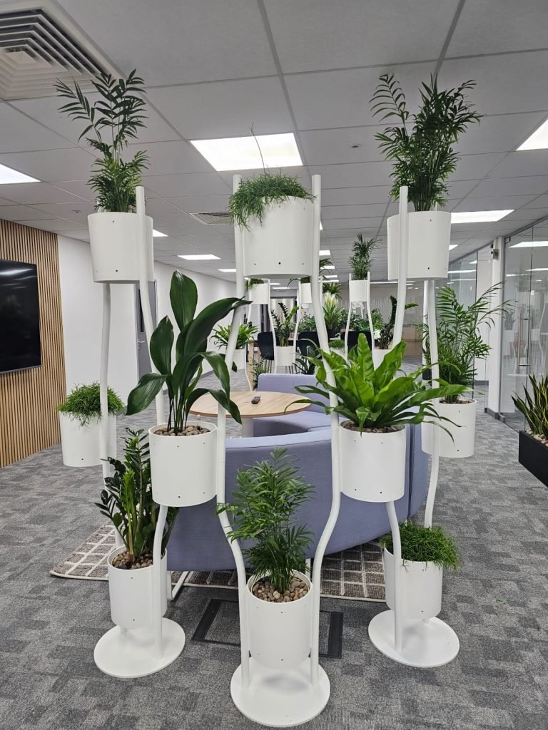 A white paravert planting system sits in a corporate waiting area as a feature planter with live mixed specimen plants