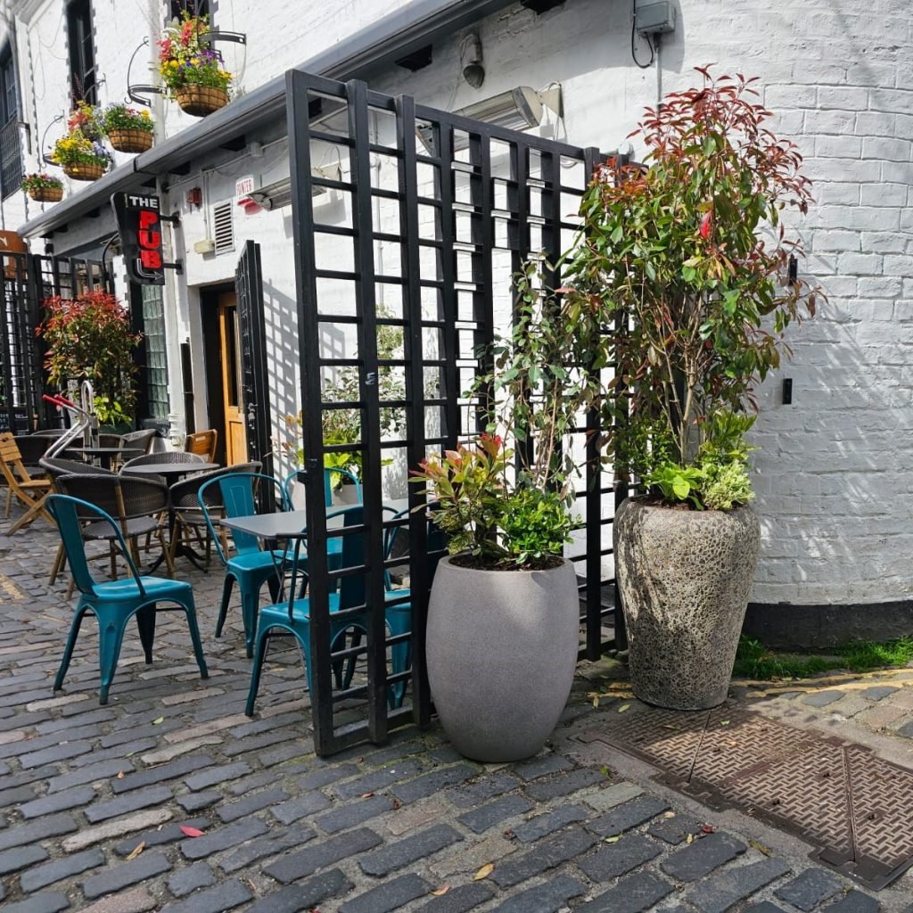two natural stone feature planters with live plants sit beside a pub's outdoor eating area