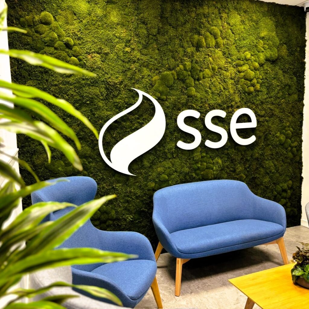 A beautiful lit nordik bun and flat moss wall stands in SSE’s corporate seating area with a branded sign atop