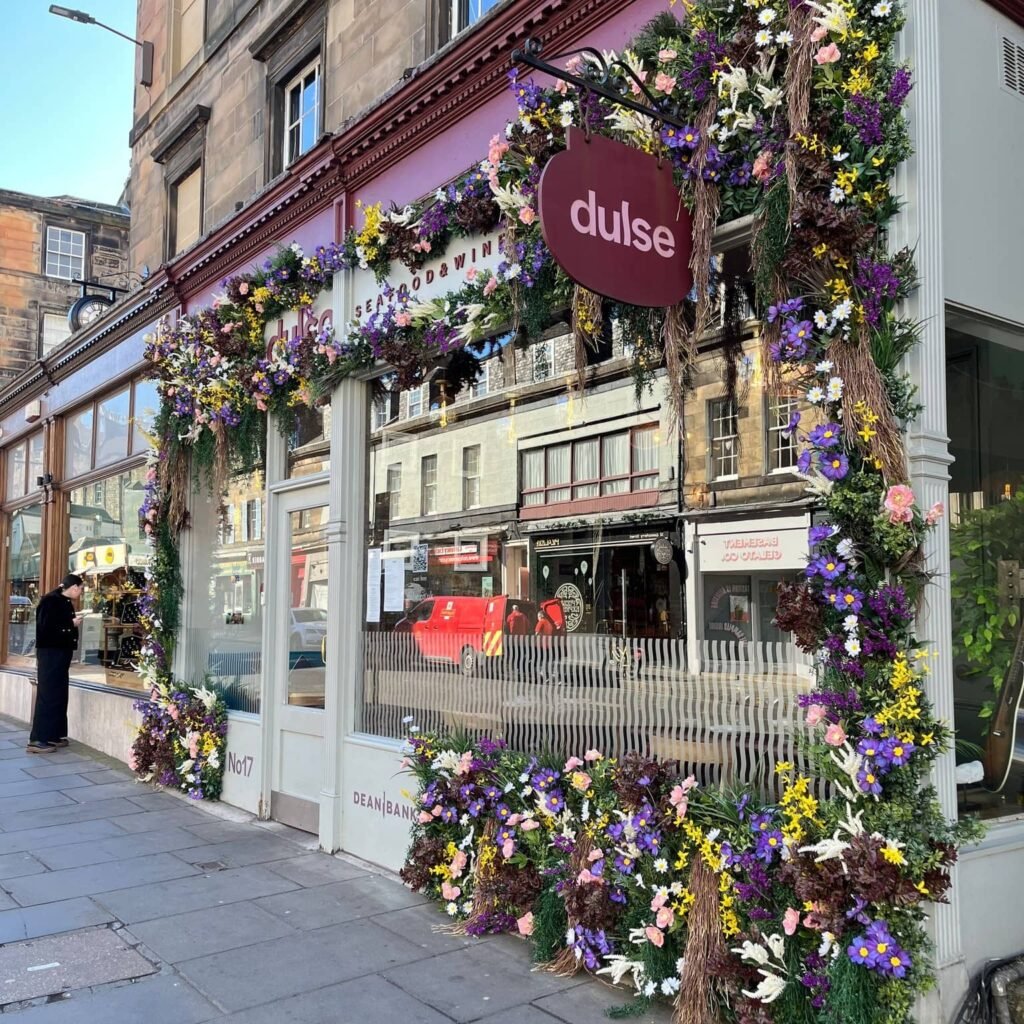 purple-pink-yellow-white-artificial-flowers-and-green-foliage-surround-dulse-restaurant-edinburgh
